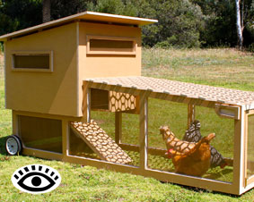 Photo of a home made chicken tractor with wheels at one end.