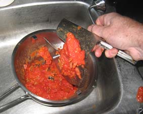 Photo of a mouli showing the tomato skins left in the sieve