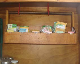 Photo of a seed storage box suspended on hooks to protect seeds form rodents.