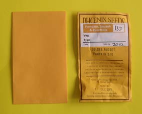 Photo of a blank paper envelope and a commercial seed packet.