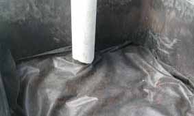 Photo of wicking bed with weed mat coveing stones