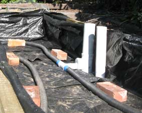 Photo of the bottom of a wicking bed with agricultural pipe laid out.